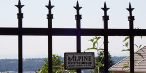 A decorative iron fence in Seattle featuring a sign that reads "Alpine" attached to it.